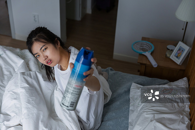 夜晚蚊虫侵扰，喷洒杀虫剂图片素材