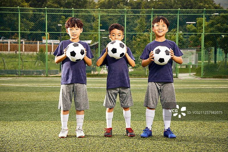 孩子们在足球场上踢足球图片素材