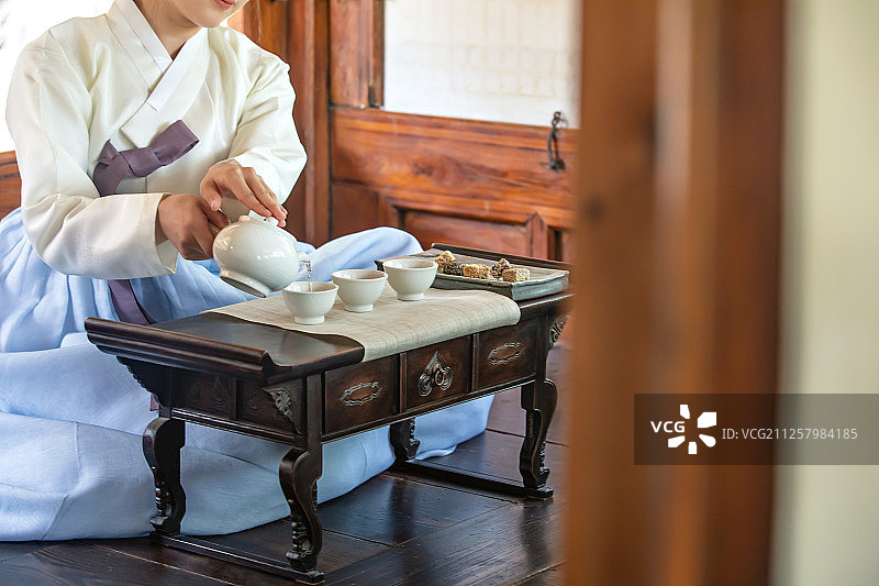 传统文化茶道：茶壶、茶、桌子、木制品与女性图片素材