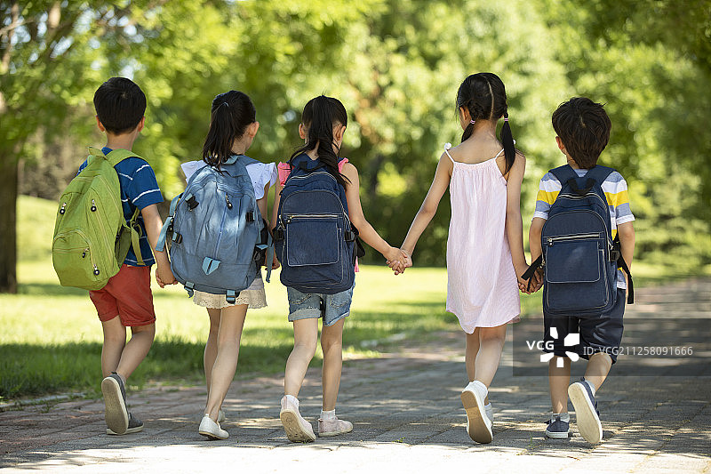孩子们背着书包去上学图片素材