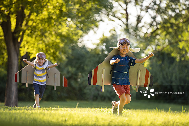 快乐的小男孩在草地上玩耍图片素材