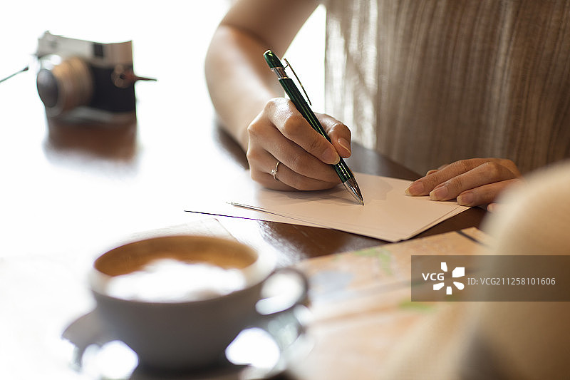 优雅女士在咖啡店写明信片图片素材