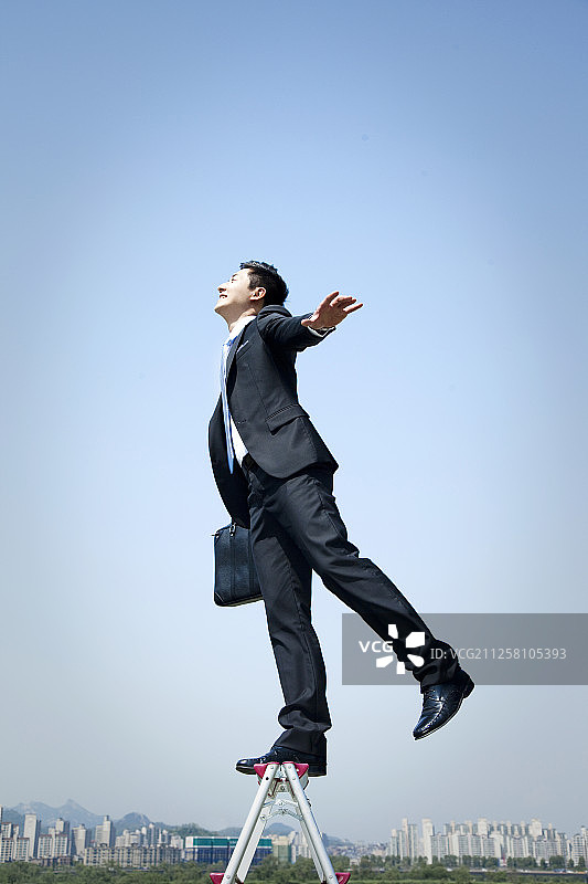 手提公文包的商人在汉江边梯子上摆姿势图片素材