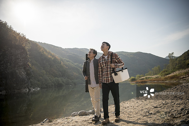 父子在河边拿着工具箱散步的摄影作品图片素材