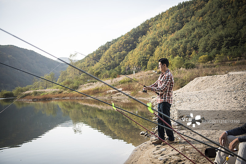 男子在河里钓鱼的照片图片素材