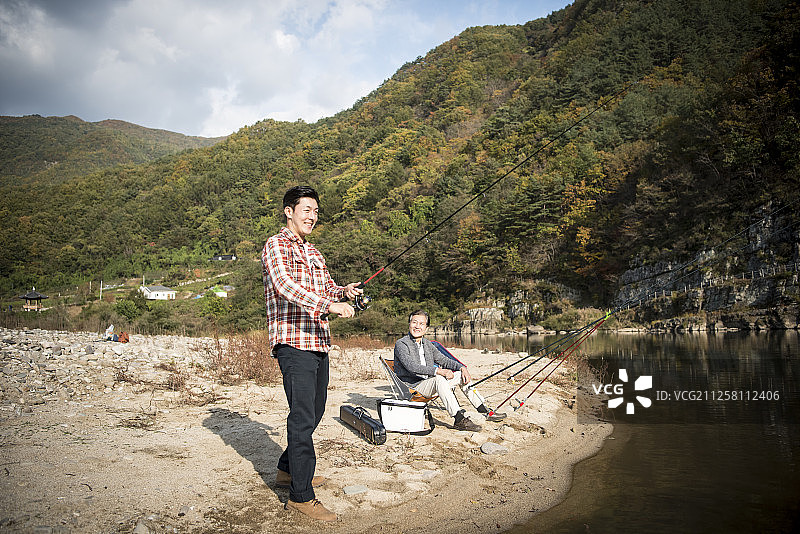 父子在河里钓鱼的照片图片素材