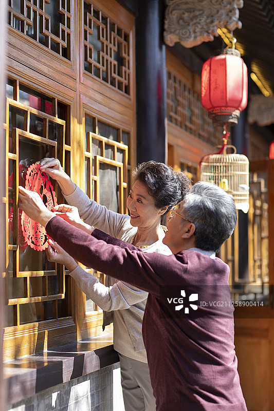 老年夫妇一起贴窗花图片素材