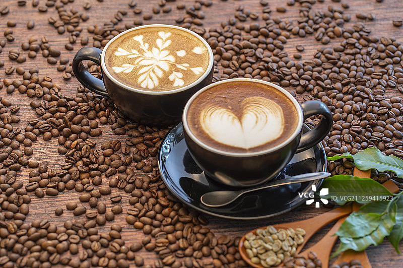 二杯含有漂亮拉花的拿铁咖啡和不同烘焙程度的咖啡豆图片素材