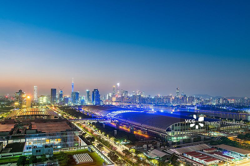 晴朗天气下的广交会展馆与城市天际线日落夜景图片素材