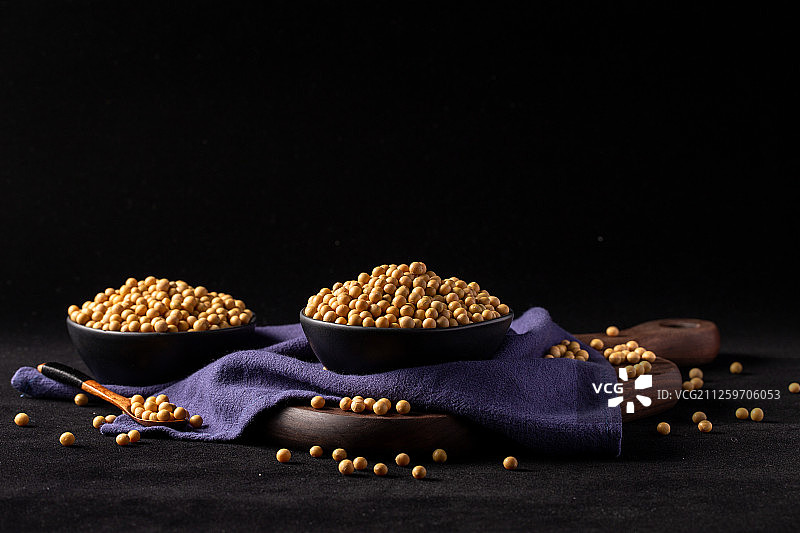黑色背景上满满一碗大黄豆图片素材