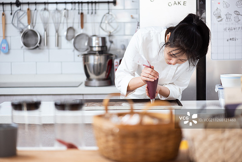 亚洲女性烘焙师制作马卡龙图片素材