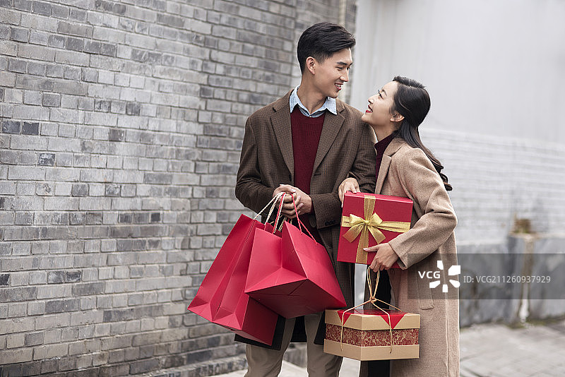 快乐的年轻情侣提着礼物图片素材