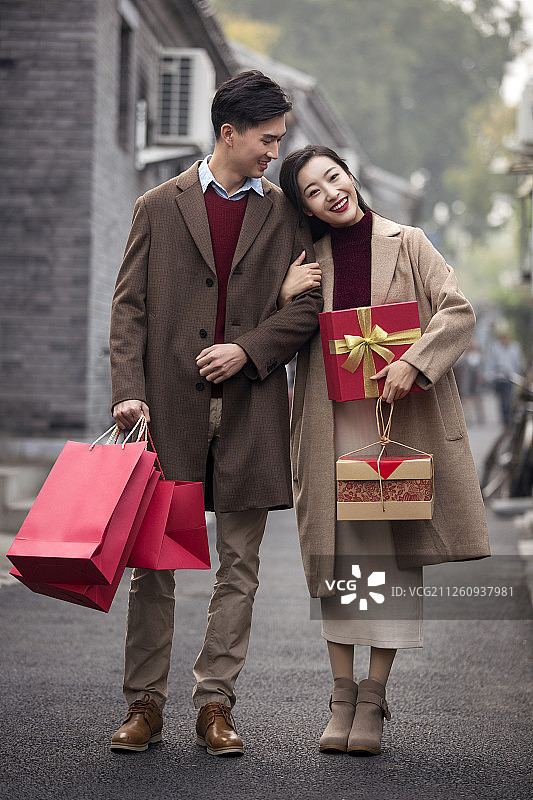 快乐的年轻情侣提着礼物图片素材