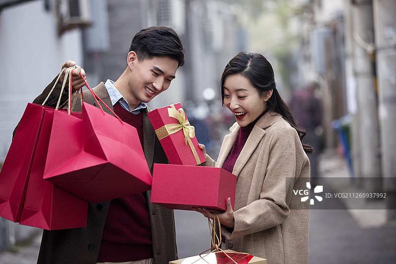 快乐的年轻情侣提着礼物图片素材