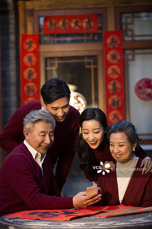 快乐的一家人新年使用智能手机视频通话图片素材