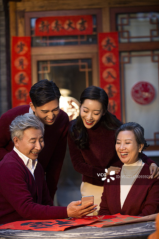 快乐的一家人新年使用智能手机视频通话图片素材