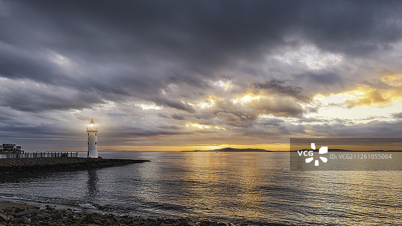 厦门会展中心海岸线上的灯塔日出图片素材