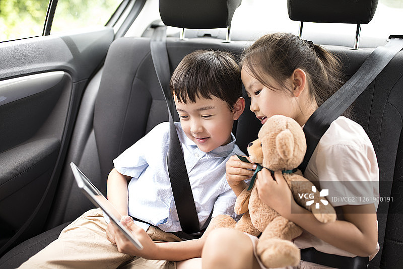 兄妹在车内使用平板电脑图片素材