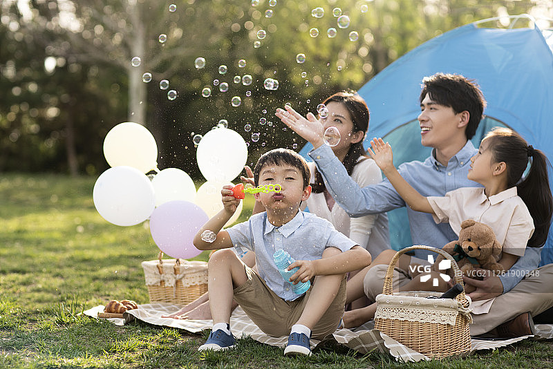 年轻家庭在户外野餐游玩图片素材