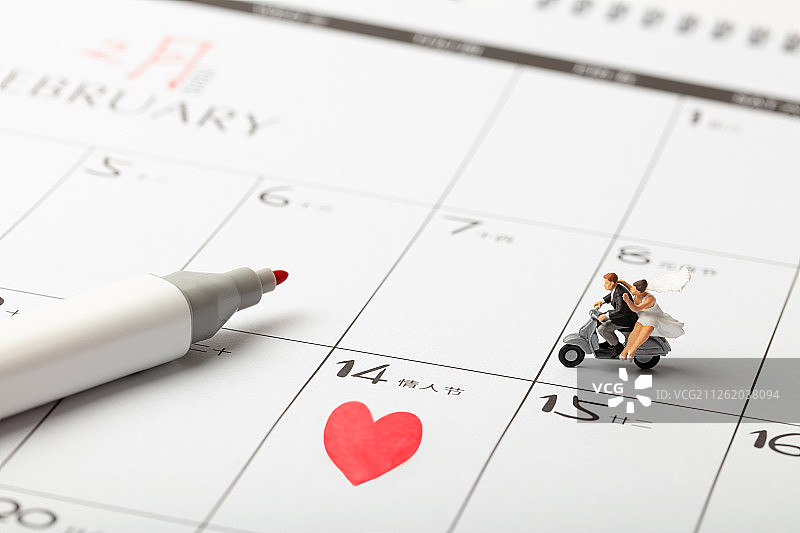 情人节的新婚夫妇在爱心日历上骑摩托车图片素材