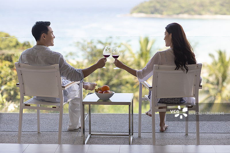 年轻夫妇在露台喝红酒图片素材