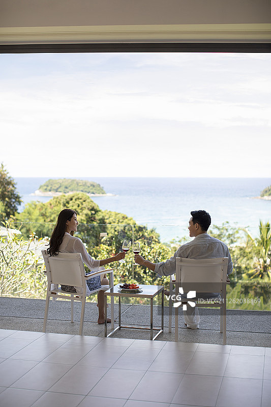 年轻夫妇在露台喝红酒图片素材