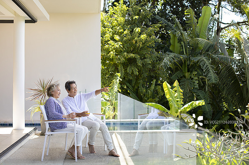 快乐的老年夫妇在阳台喝酒图片素材