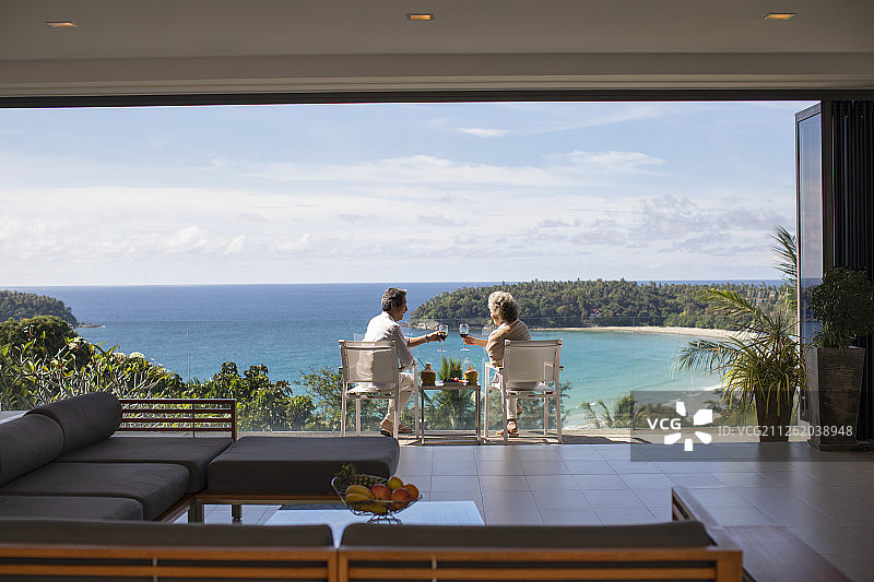快乐的老年夫妇在阳台喝红酒图片素材