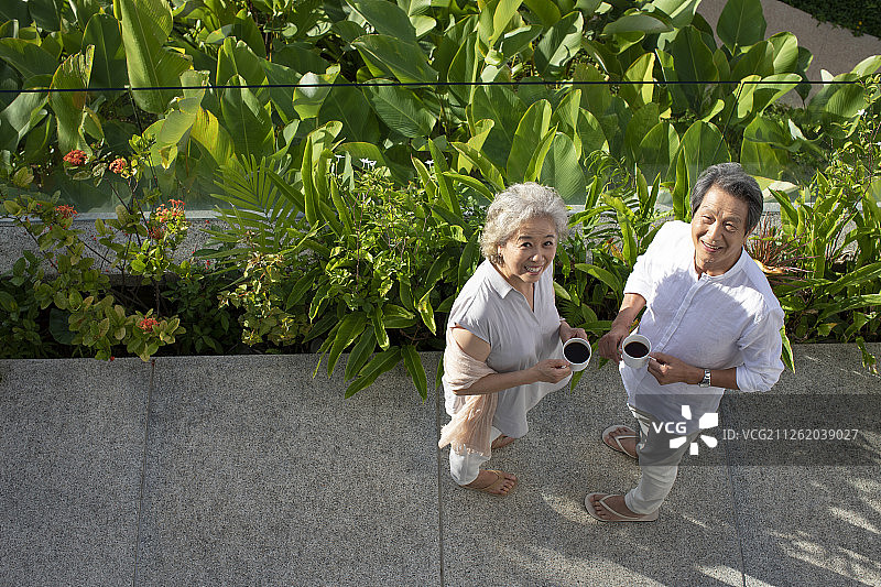 快乐的老年夫妇在阳台喝咖啡图片素材