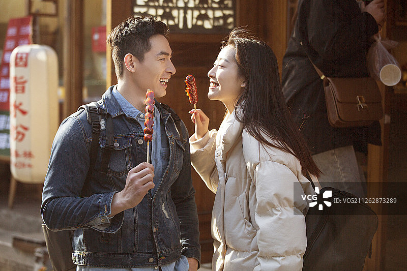 快乐的情侣在游玩吃冰糖葫芦图片素材
