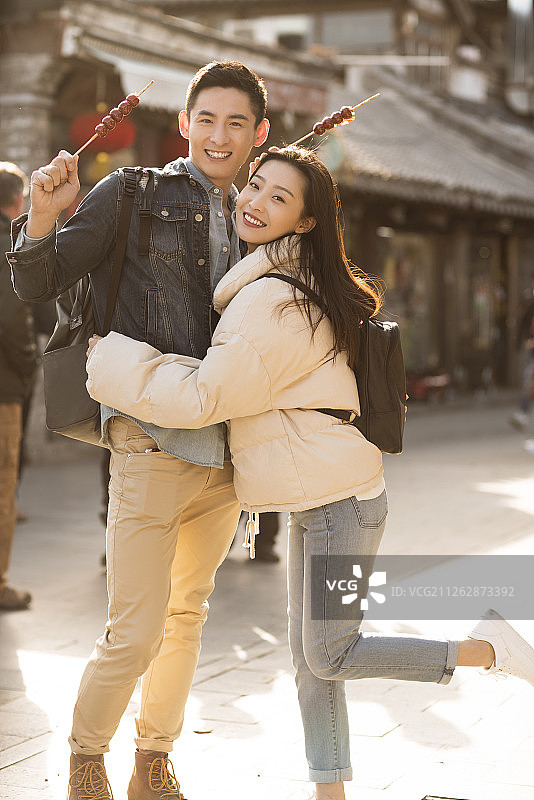 快乐的情侣在游玩吃冰糖葫芦图片素材