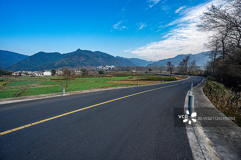 蓝天白云下的中国安徽省黄山市宏村旁的柏油路图片素材
