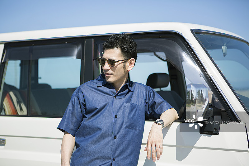 中年男人倚靠在汽车旁图片素材