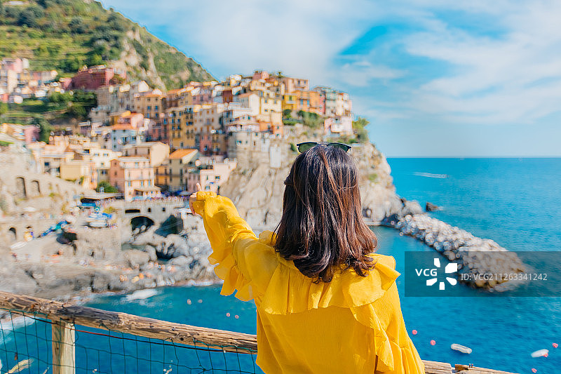 意大利著名旅游景点五渔村阳光下少女兴奋的背影图片素材