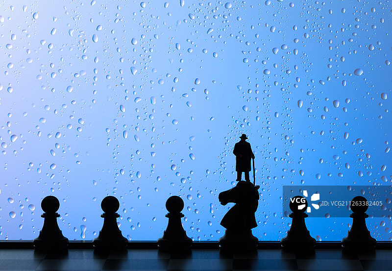 雨天窗户下在棋盘上思考的商务男性图片素材