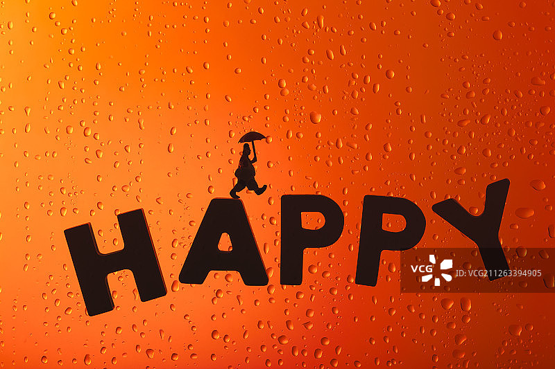 雨滴玻璃窗上撑伞的小丑在happy上行走图片素材