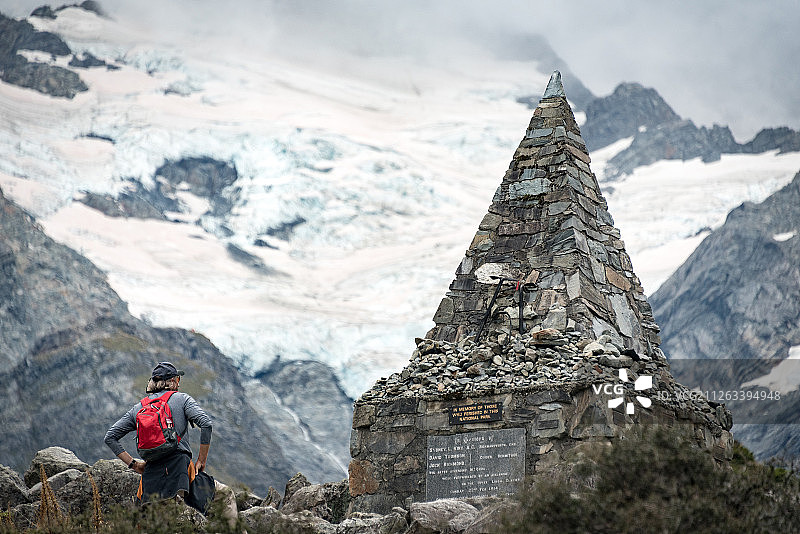 冰川下，一个户外运动爱好者注视着山难纪念碑图片素材