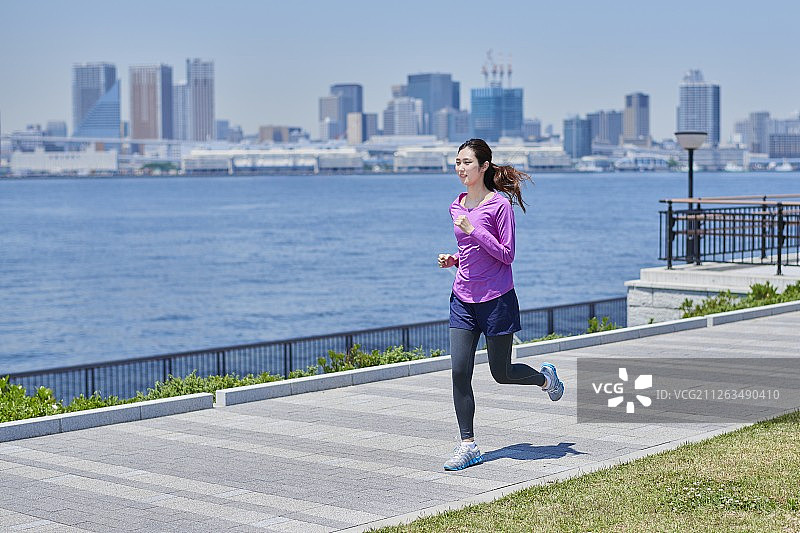在东京闹市区跑步的日本年轻女子图片素材