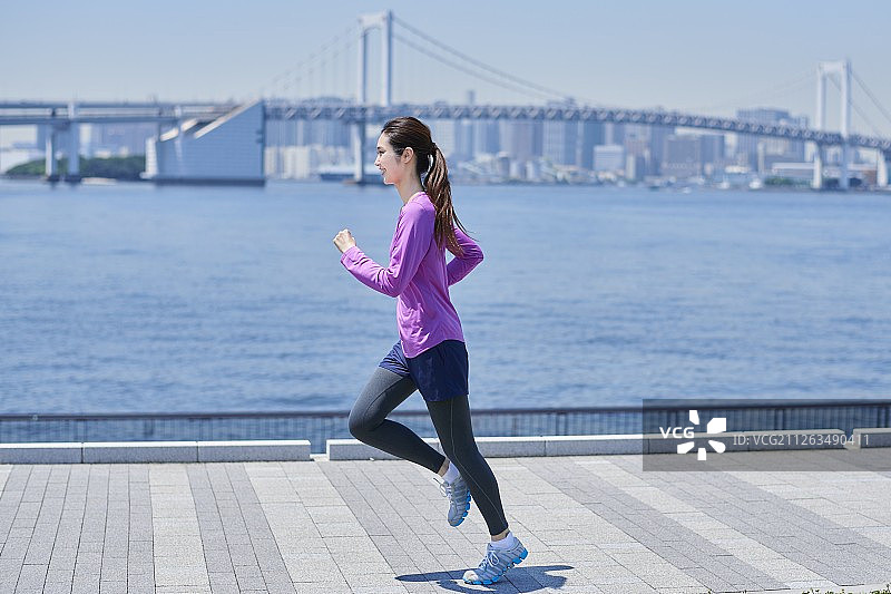 在东京闹市区跑步的日本年轻女子图片素材