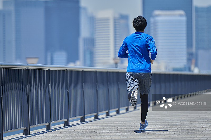 在东京市区跑步的年轻日本男子图片素材