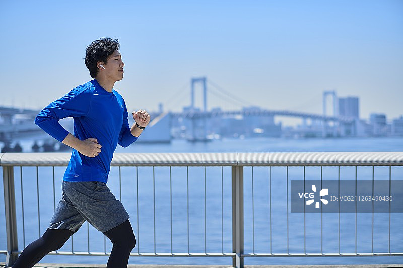 在东京市区跑步的年轻日本男子图片素材