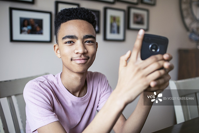 使用智能手机的自信青少年男孩肖像图片素材