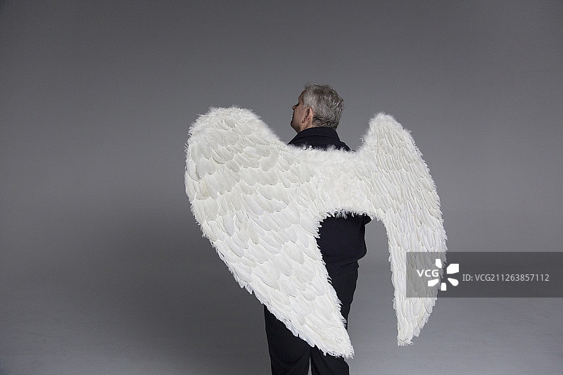 宁静男人身着天使翅膀仰望图片素材