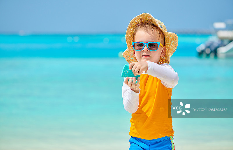三岁幼儿在海滩上玩沙滩玩具，马尔代夫夏季家庭度假图片素材