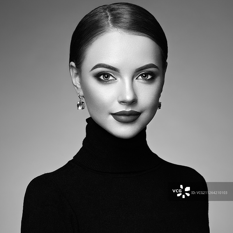 年轻漂亮的女人拥有洁净清新的肌肤。完美的妆容。美容时尚。丰满的嘴唇。化妆眼影。柔顺的头发。穿黑色高领毛衣的女孩。黑白照片图片素材