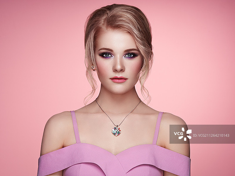 佩戴珠宝的美丽金发女郎，粉色礼服图片素材