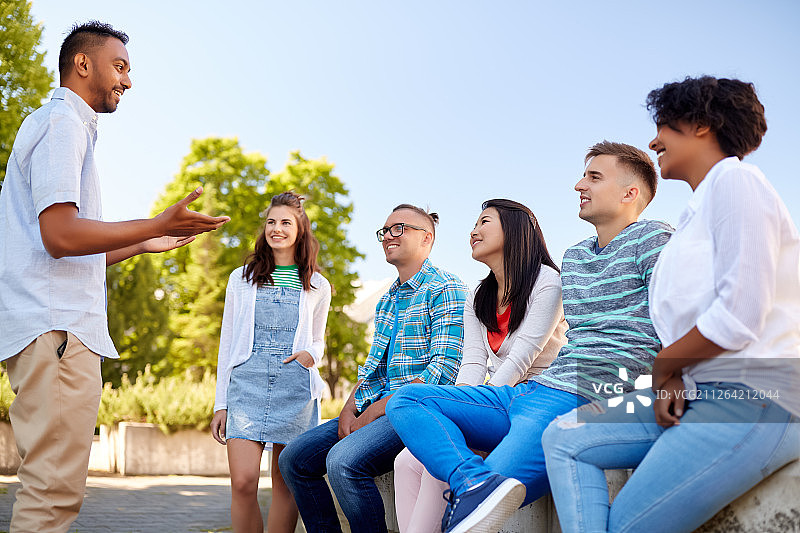 人物，友谊和交流概念 - 一群快乐的国际朋友在城市里交谈图片素材