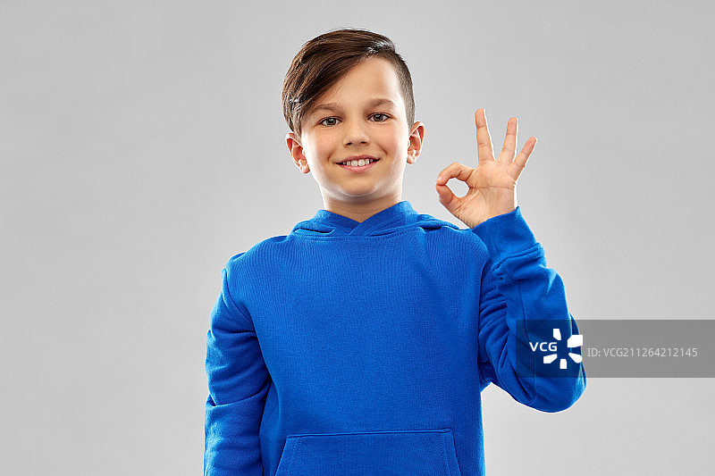 儿童手势人物概念：蓝色连帽衫男孩做出OK手势图片素材