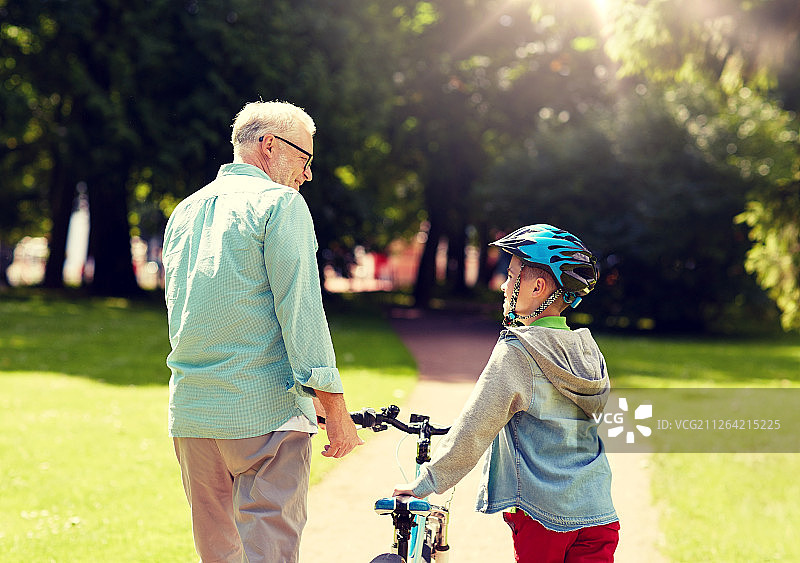 家庭安全理念：快乐的祖父和孙子在公园里交谈图片素材