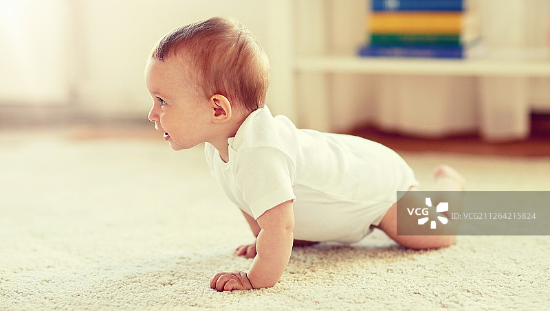 儿童宝宝概念：宝宝在家在地板上爬行图片素材